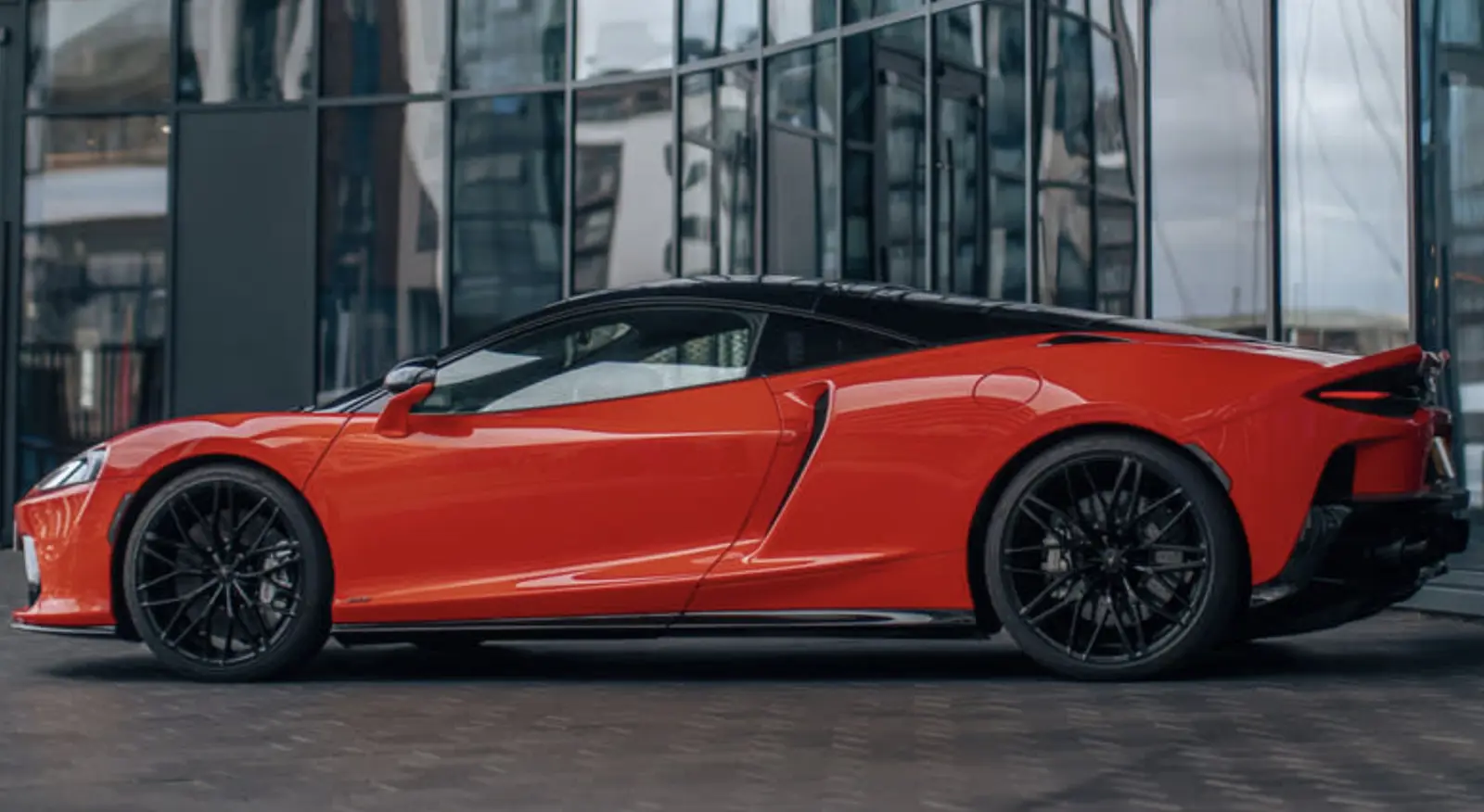 سيارة ماكلارين GTS 2025 برتقالية اللون من الجهة الجانبية.